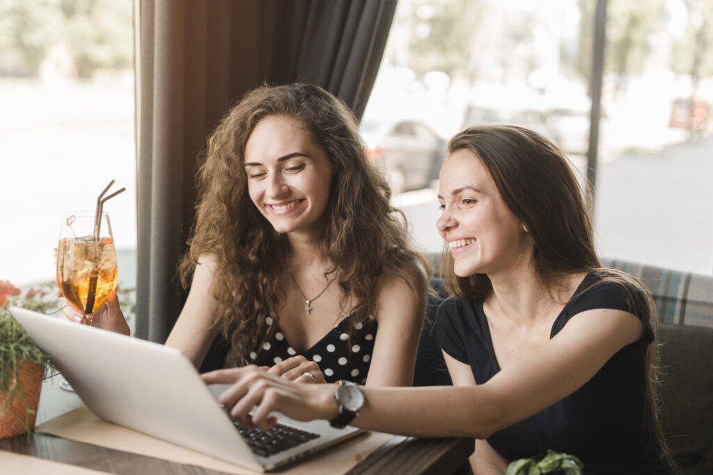 KI-Coaching new smiling young woman sitting restaurant looking laptop