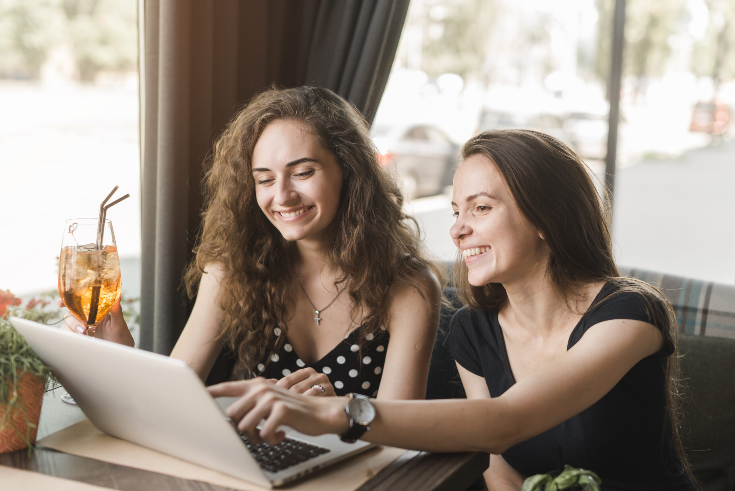 KI-Coaching new smiling young woman sitting restaurant looking laptop